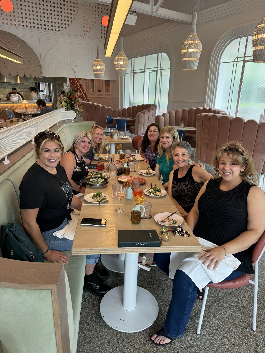 Women gathered around a table in Detroit, laughing together over a shared meal.